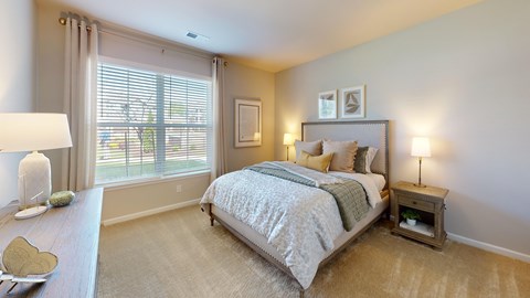 a large bedroom with a ceiling fan and window
