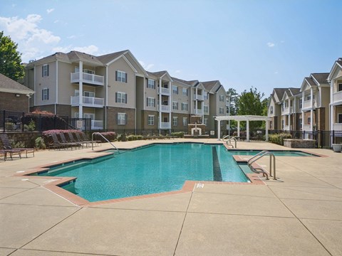 A large swimming pool in front of apartment buildings.