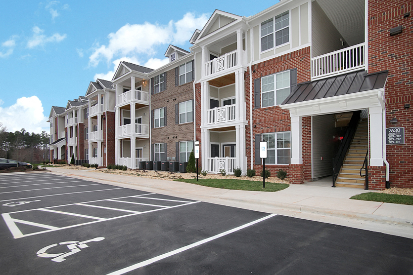Apartment buildings with patio or balcony; parking lot