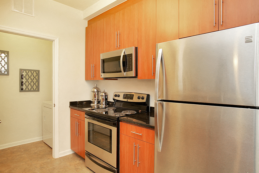 Kitchen with stainless steel appliances; door to laundry area