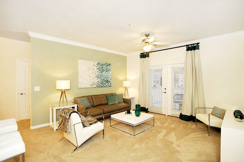 Living room with ceiling fan and door to patio