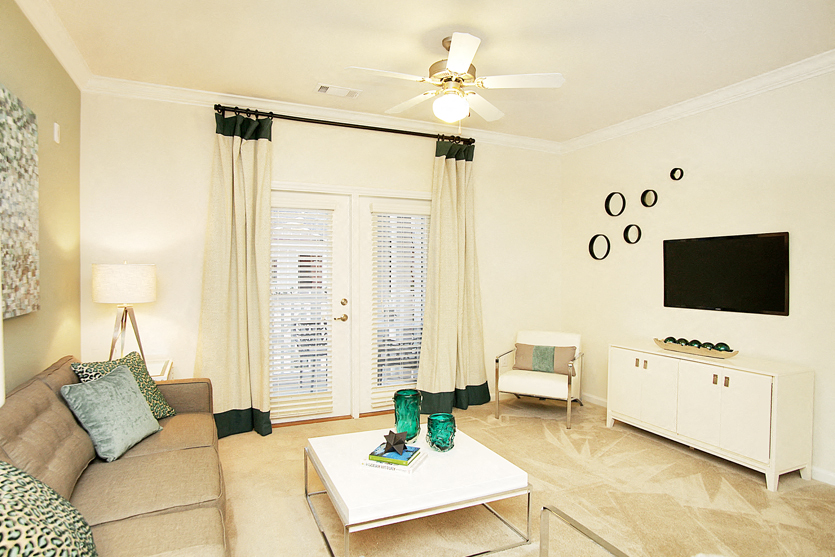 Living room with ceiling fan and door to patio