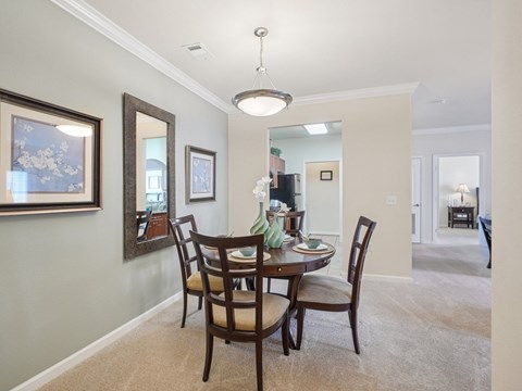 A dining room with a table set for four.