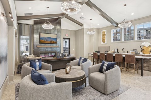 A living room with grey couches and a large painting on the wall.