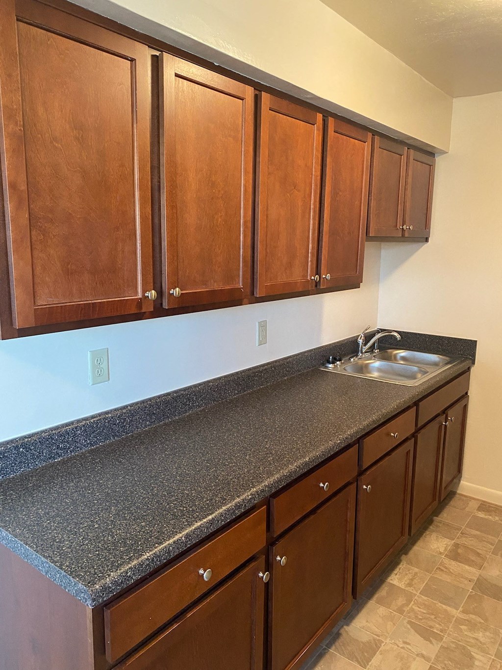 a kitchen with a granite counter top and wooden cabinets