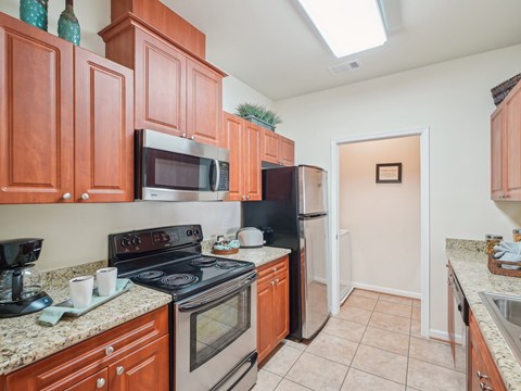 A kitchen with brown cabinets and black appliances.