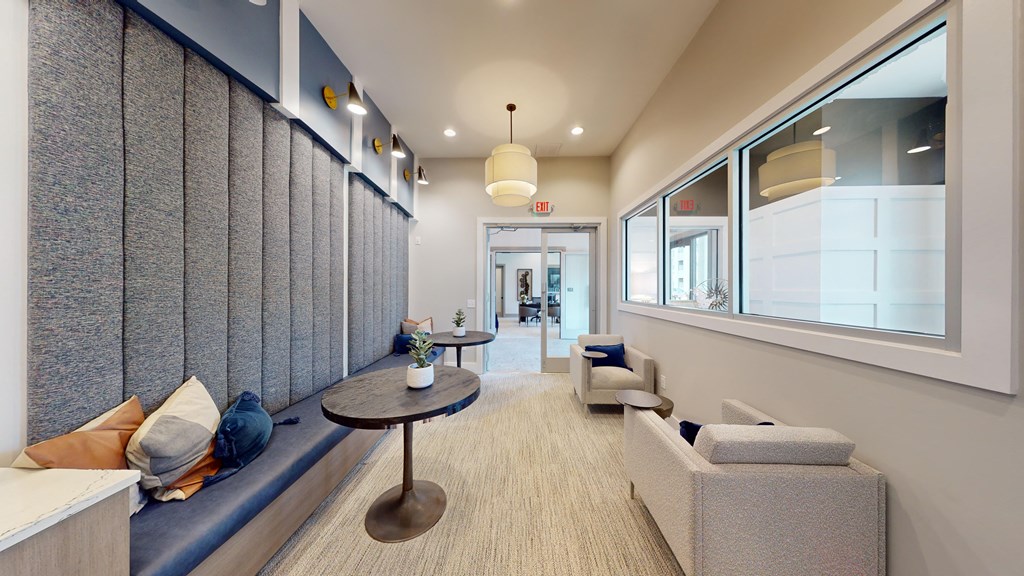 a lobby with couches and tables and a large window