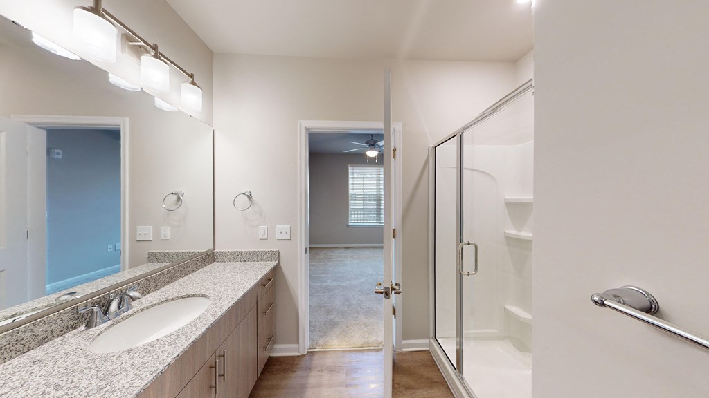 a bathroom with a shower and a sink and a mirror