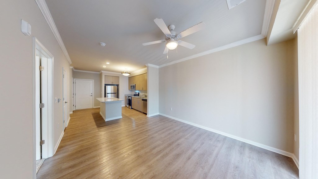 a living room with wood floors and a ceiling fan