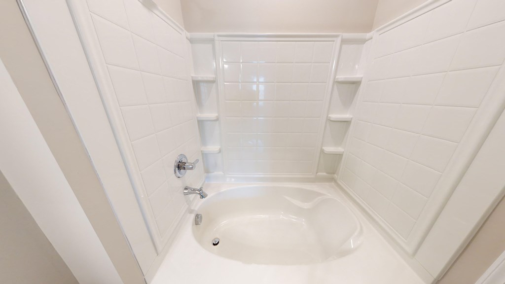 a small white bathroom with a shower and sink