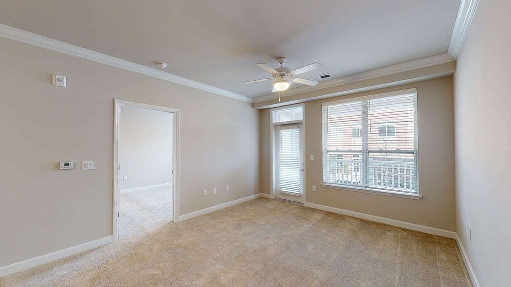 Living room with ceiling fan and door to patio