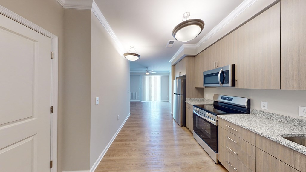 a kitchen with wood flooring and stainless steel appliances and