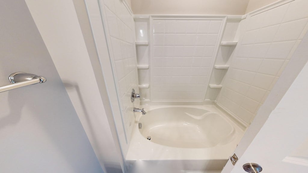 a small bathroom with a toilet and white tiles