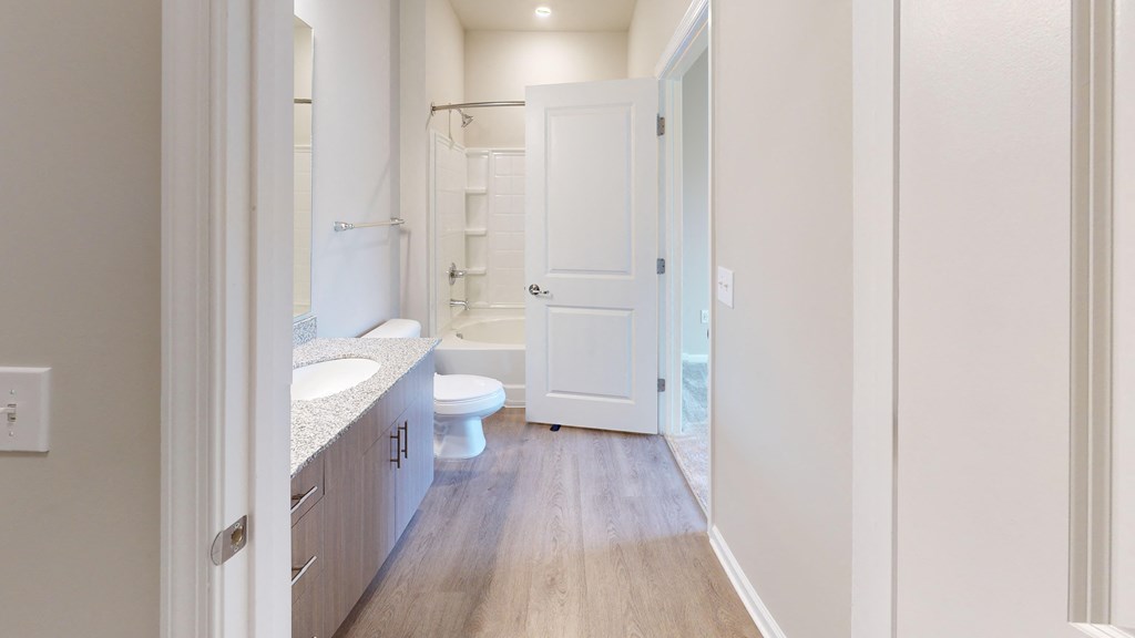 a bathroom with a white door and a toilet and a shower