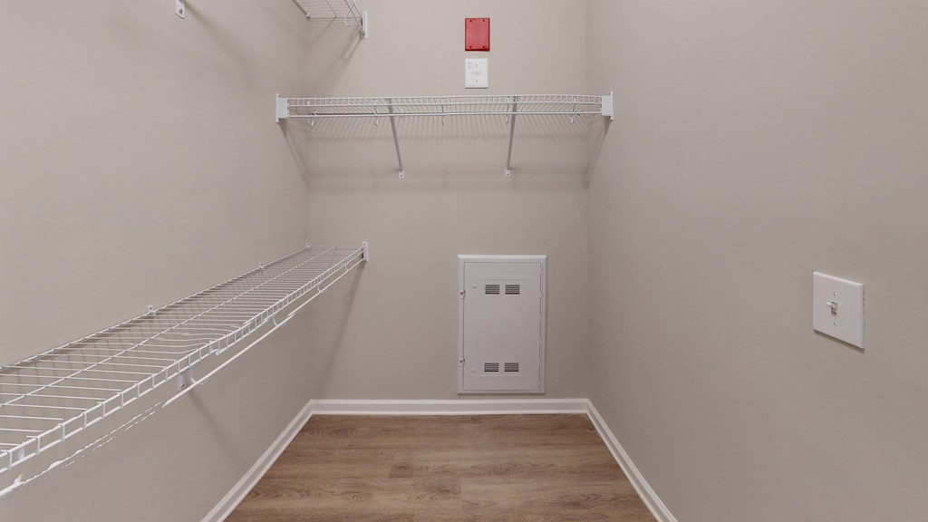 a room with a white closet and a shelf on the wall
