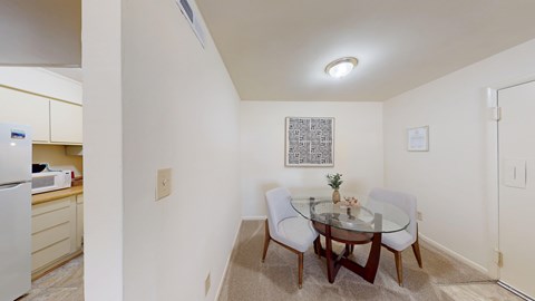 A dining room with a glass table and chairs.