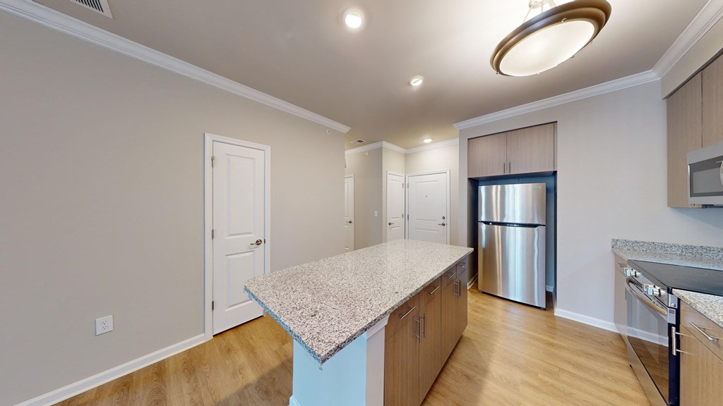 a kitchen with a granite counter top and a stainless steel refrigerator