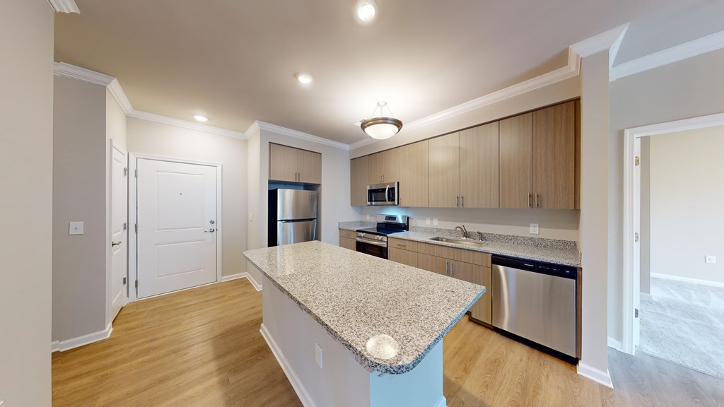 A kitchen with a granite countertop and wooden cabinets.