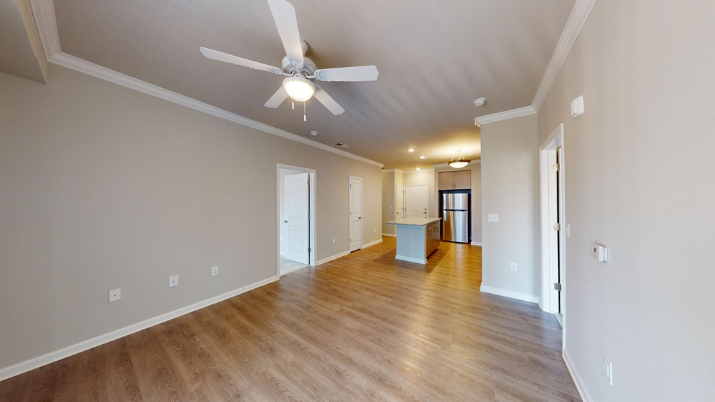 a living room with a ceiling fan and a hard wood floor