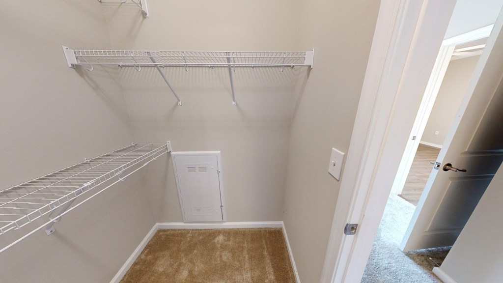 an empty closet in a home with a white closet rack