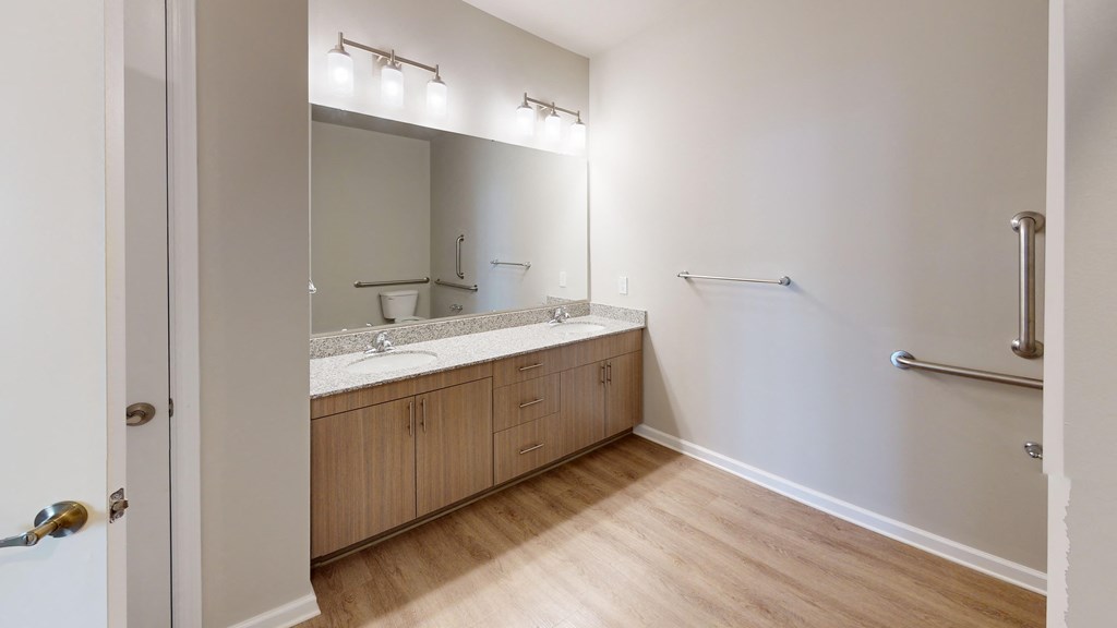 a bathroom with wood flooring and a large mirror