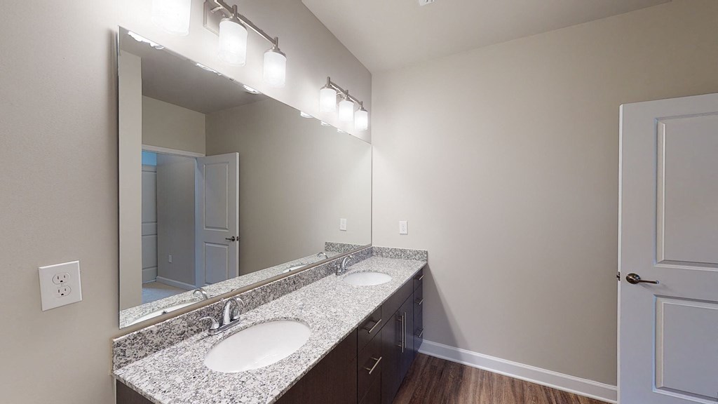Bathroom with dual sinks and dark cabinets