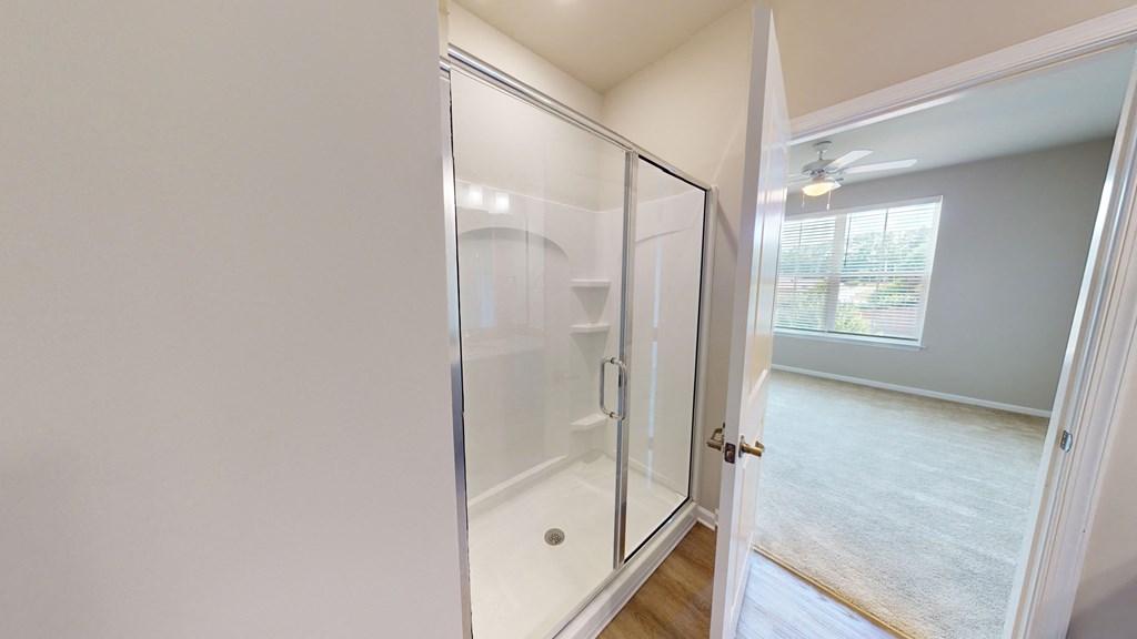 an empty bathroom with a shower and a window