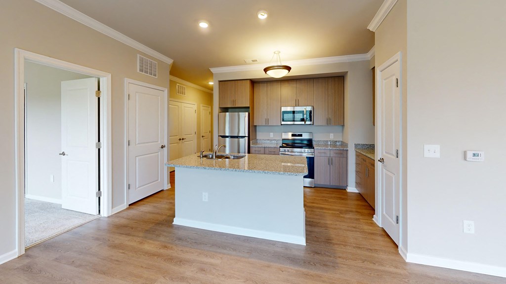a large kitchen with a large island and a white counter top