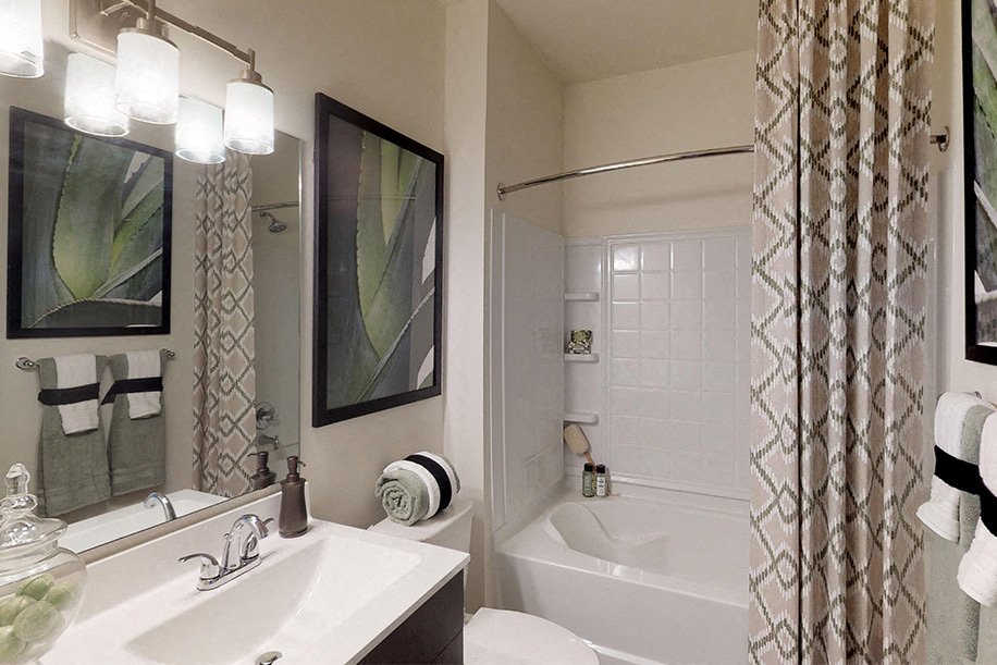 Bathroom with dark cabinets, sink and garden-style bathtub