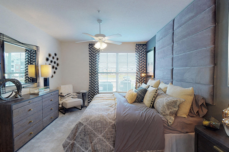 Bedroom with ceiling fan; window; door to in-room bathroom
