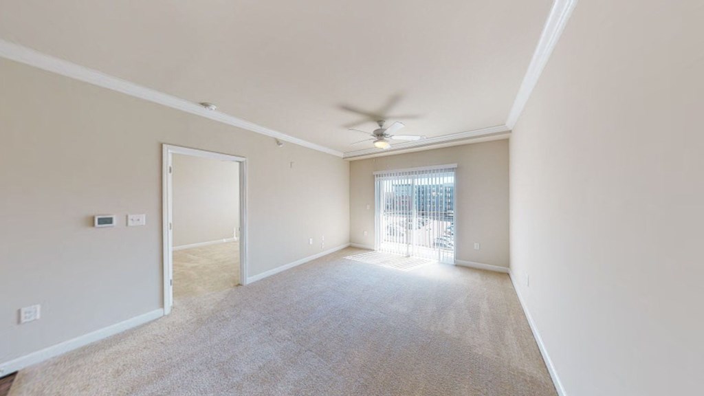 Living room with carpet; ceiling fan; door to patio