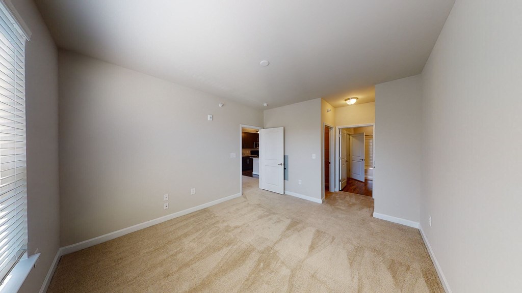 Bedroom with carpet; door to bathroom