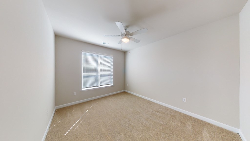 Bedroom with ceiling fan, carpet and door to bathroom