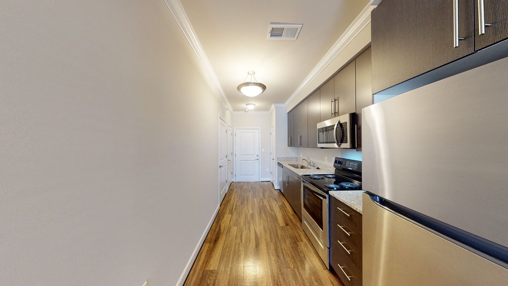 Kitchen with dark cabinets, granite countertops, vinyl wood plank floors
