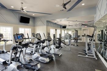 Fitness center with cardio and resistance training equipment; flat screen TV