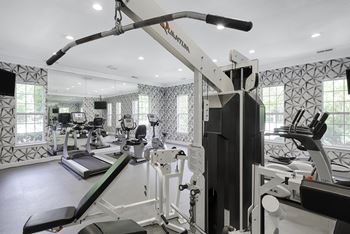 Fitness center with cardio and resistance training equipment; flat screen TV