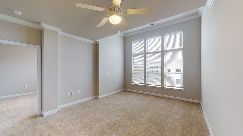 Living room and sunroom with ceiling fan; large windows; carpet