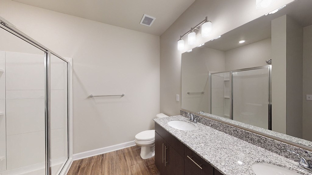 Bathroom with dual sinks, shower, dark cabinets
