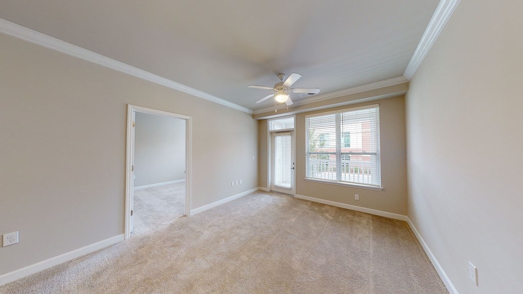 Living room with ceiling fan and door to patio