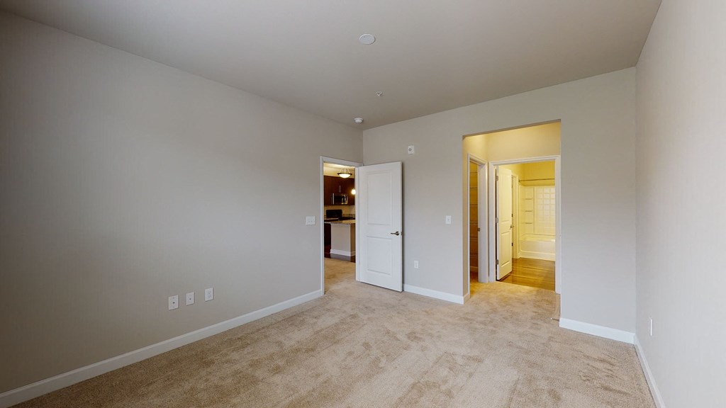 Bedroom with carpet; door to bathroom