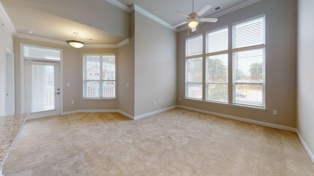 Living room with ceiling fan, high ceilings and door to balcony