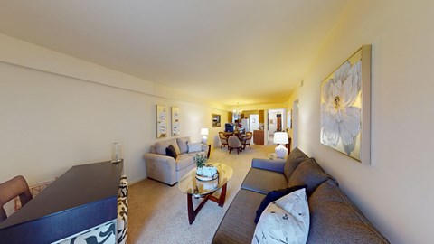 A living room with a couch, coffee table, and a painting on the wall.