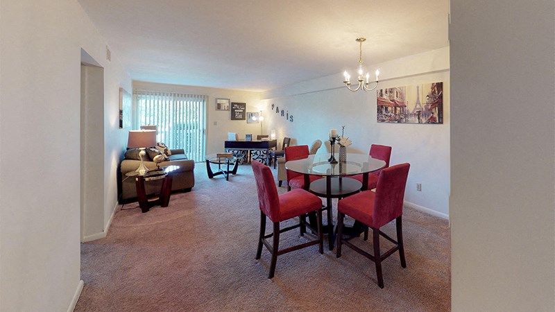 a living room and dining room with a table and chairs