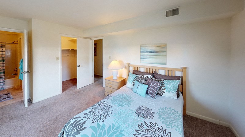 a bedroom with a bed and a door to a bathroom