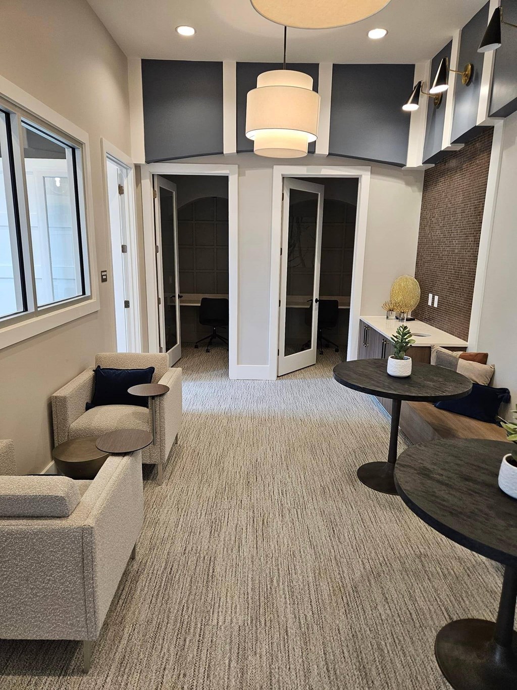 clubhouse and office space with couches and tables and a hallway with open doors