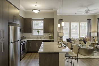 Kitchen with dark cabinets, granite countertops, vinyl wood plank floors; island; open to living room - Photo Gallery 26
