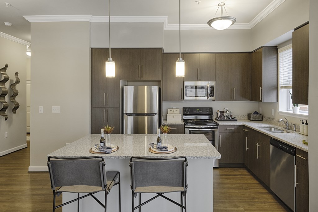 Kitchen with island, dark cabinets, vinyl floors and granite countertops