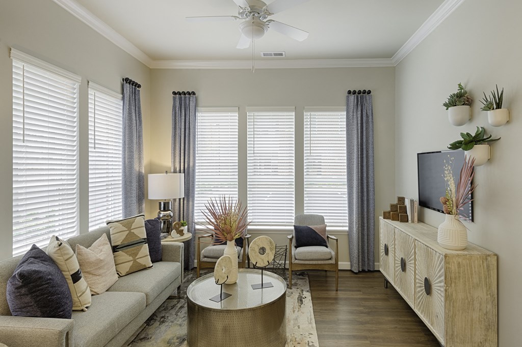 Living room with ceiling fan, high ceilings and vinyl plank floors