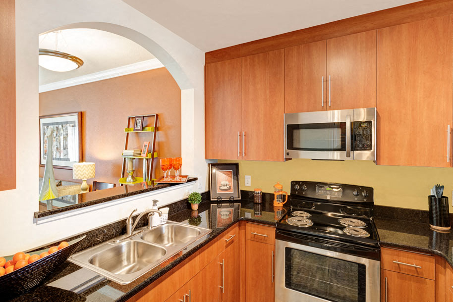 Kitchen with black granite countertops; opening to living room