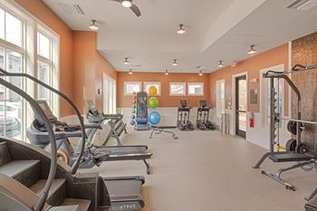A gym with treadmills, elliptical machines, and other exercise equipment.